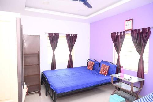 Un dormitorio con una cama azul y una ventana. en Beautiful GardenTerrace 2 Bhk in Posh city center, en Bhubaneshwar