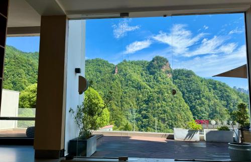 a room with a view of a mountain through a window at 云漫山居民宿 in Xinglong