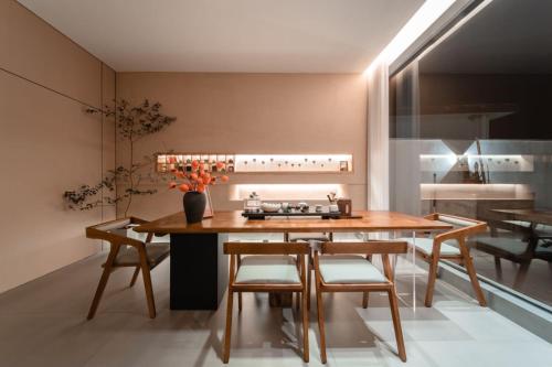 a kitchen with a wooden table and chairs and a sink at 云漫山居民宿 in Xinglong
