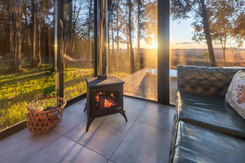 a fireplace in a living room with a view of a lake at El Alcanfor in Chivilcoy