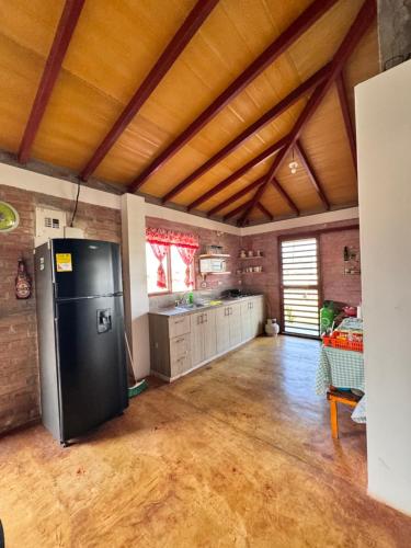 a large kitchen with a black refrigerator in a room at Casa Campestre Lago Calima in Calima