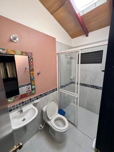 a bathroom with a toilet and a sink and a shower at Casa Campestre Lago Calima in Calima