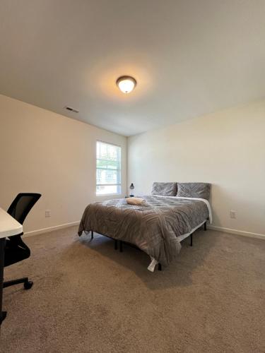 een slaapkamer met een bed, een bureau en een raam bij Peaceful room in new house in Raleigh Downtown Area in Raleigh