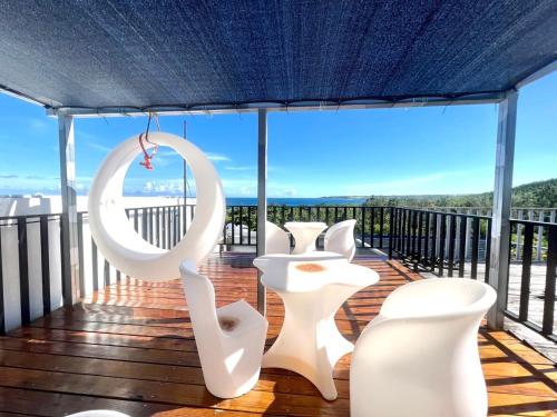 a balcony with white chairs and a view at Nanwan254 Homestay in Nanwan