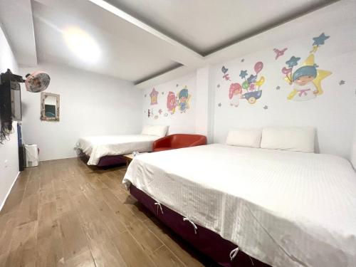 two beds in a room with white walls at Nanwan254 Homestay in Nanwan