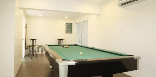 a billiard room with a pool table and some stools at Cozy Studio Condo in Dumaguete