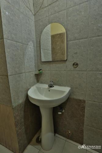 a bathroom with a white sink and a mirror at Hotel Haridev in Roorkee