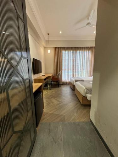 a hotel room with a bed and a desk at Hotel Mumbai House Mindspace Malad in Mumbai