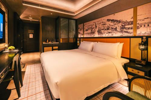 a bedroom with a large white bed and a desk at Hotel Central 新中央酒店 in Macau