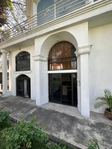 a large white building with large glass doors at Casa Camelina in Cuernavaca