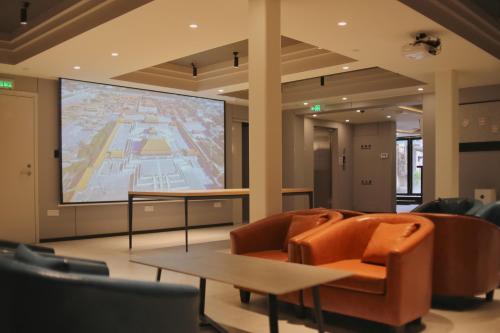 a large projection screen in a room with chairs at Dayin Youth Hostel - Old Town & People's Square& Rail Hub -Social Area -Bar -Café -Gym -Free Laundry Luggage Storage -24H Front Desk -English Service in Shanghai