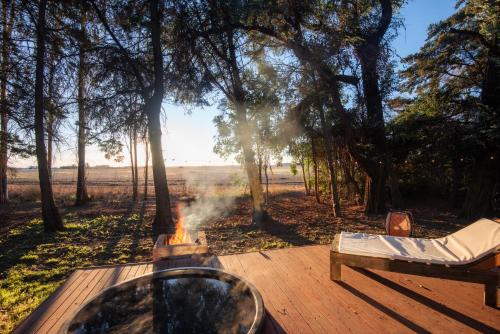 a fire pit on a wooden deck in a forest at El Alcanfor in Chivilcoy