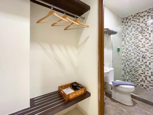 a bathroom with a toilet and a box on a bench at Hotel 88 Embong Kenongo - Kayun By WH in Surabaya