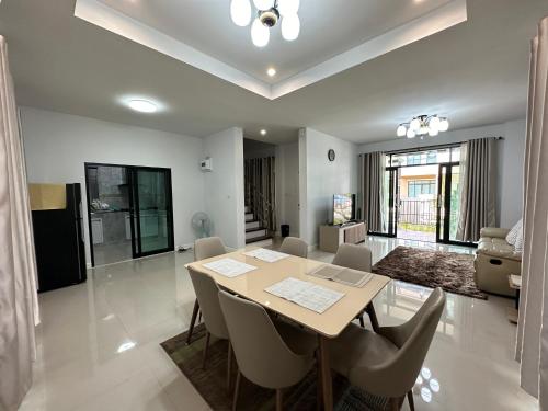 een eetkamer en woonkamer met een tafel en stoelen bij PS home โฮมฮักขอนแก่น in Ban Non Sa-at