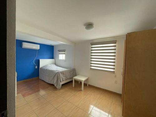 a bedroom with a bed and a blue wall at Casa familiar en Tijuana in Tijuana