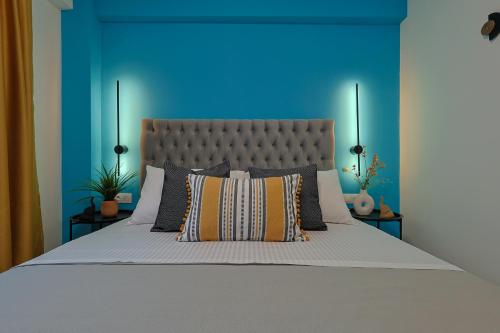 a bedroom with a large bed with a blue wall at Mythical Olympus Mare Seaside Pool Villas in Katerini