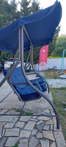a blue chair sitting on top of a stone ground at Senia Holidays in Preveza