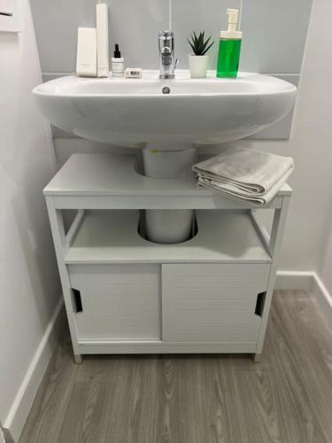 La salle de bains est pourvue d'un lavabo blanc sur une étagère. dans l'établissement Appartement F3 cozy avec balcon proche de Paris et aéroport CDG, à Villiers-le-Bel