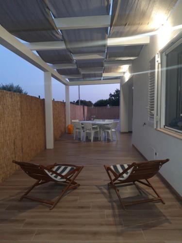 a patio with two chairs and a table and a roof at Mediterraneo Casa Vacanze -Sicilia 100 mt dal mare in Menfi