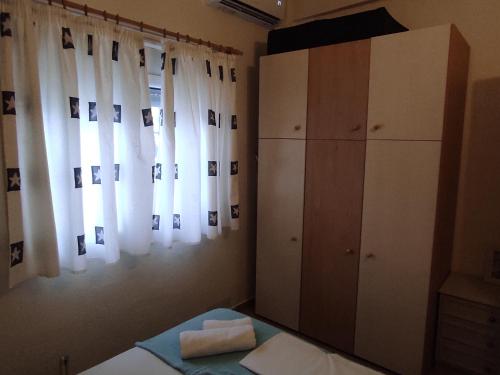 a bedroom with a bed and a dresser and curtains at Summer House 150m from the beach for 5 persons. in Sozopoli