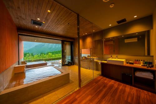 a bathroom with a tub and a sink and a window at The ACONCAGUA RESORTS in Minami Aso