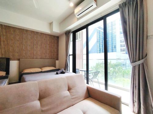 een slaapkamer met een bank en een bed en een groot raam bij Holiday At Midhills Genting Highlands Free Wi-Fi in Genting Highlands