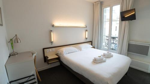 a hotel room with a bed and a window at Brit Hotel Des Grands Hommes - Bordeaux Centre in Bordeaux