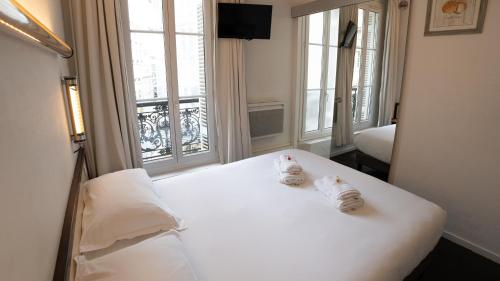 a bedroom with a white bed with towels on it at Hotel Des Grands Hommes - Bordeaux Centre in Bordeaux