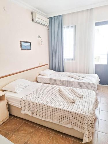 a hotel room with two beds and a window at Golden Beach Hotel in Didim