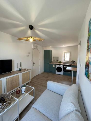 un salon avec un canapé et une cuisine dans l'établissement Charmant appartement calme et élégant à 5 min des plages, à Toulon