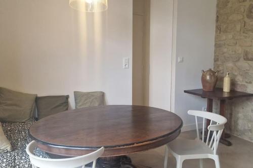 une table et des chaises en bois dans un salon dans l'établissement Le gîte Le Magnolia, à Carnac