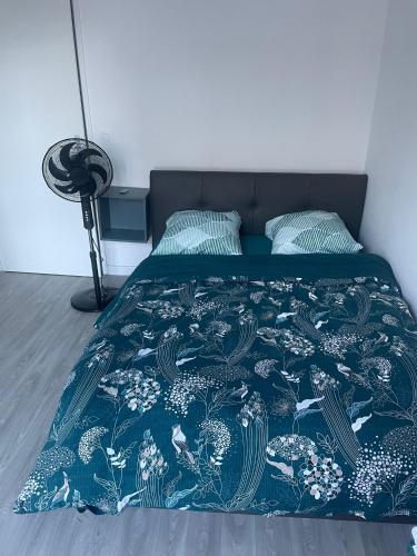 - un lit avec une couette bleue et 2 oreillers dans l'établissement Appartement F3 cozy avec balcon proche de Paris et aéroport CDG, à Villiers-le-Bel