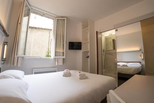 a bedroom with two beds and a window at Hotel Des Grands Hommes - Bordeaux Centre in Bordeaux