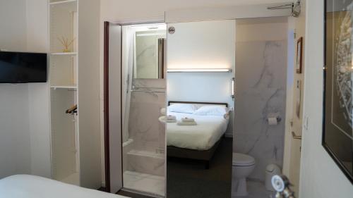 a bathroom with a bed and a shower and a toilet at Hotel Des Grands Hommes - Bordeaux Centre in Bordeaux