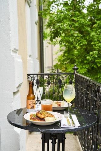 une table avec deux assiettes de nourriture et un verre de vin dans l'établissement Maison Bayard, à Montpellier