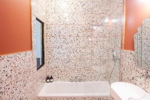 une salle de bain avec une baignoire et un lavabo dans l'établissement Maison Bayard, à Montpellier