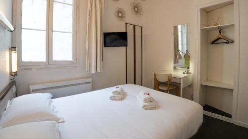 a bedroom with a white bed with two shoes on it at Hotel Des Grands Hommes - Bordeaux Centre in Bordeaux