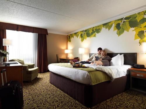 a man and woman sitting on a bed in a hotel room at Varscona Hotel on Whyte in Edmonton