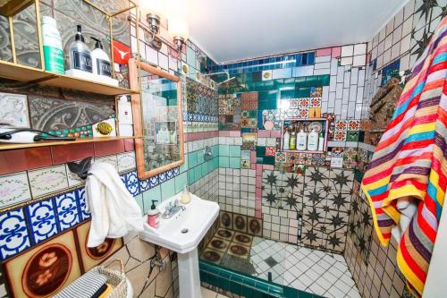 a bathroom with a sink and a tiled wall at The Desert Shire Stargazing,Cold Plung & LargeSpa in Yucca Valley