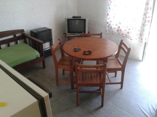 a room with a table and chairs and a television at La Casa del Caminante in Aguas Dulces