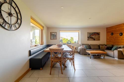 - un salon avec une table et une horloge murale dans l'établissement appartement en chalet individuel sauna piscine, à Valmeinier