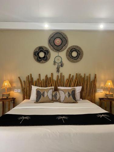 a bedroom with a large bed with a wooden headboard at Living Trawangan Hotel in Gili Trawangan