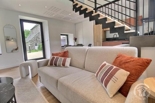 a living room with a couch and a kitchen at Rubis in Troguéry