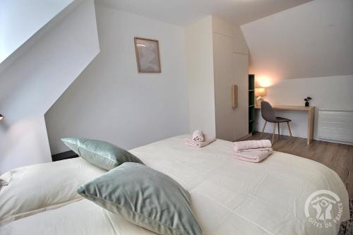 a bedroom with a large white bed with pillows at Rubis in Troguéry