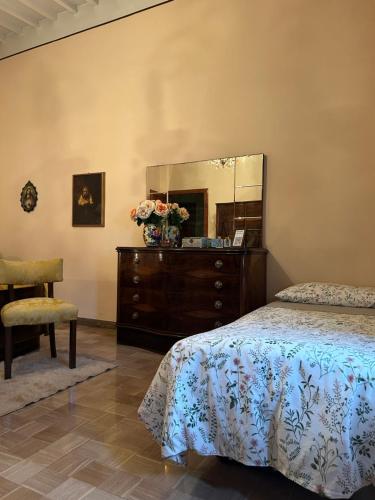 a bedroom with a bed and a dresser with a mirror at Villa Ada in Monsummano