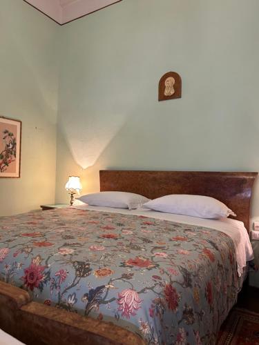 a bedroom with a bed with a floral bedspread at Villa Ada in Monsummano