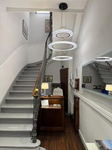 a hallway with a staircase with a chandelier at Hotel Des Grands Hommes - Bordeaux Centre in Bordeaux