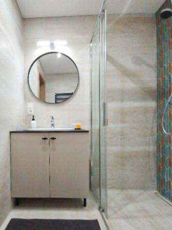 a bathroom with a shower and a sink with a mirror at Rossak apartment 2 in Panevėžys