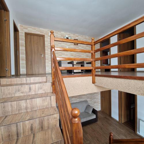 a staircase in a house with wooden railing at Casa Diana in Curtea de Argeş