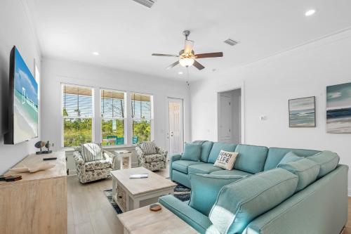 a living room with a blue couch and chairs at Sandy Cheeks in Orange Beach